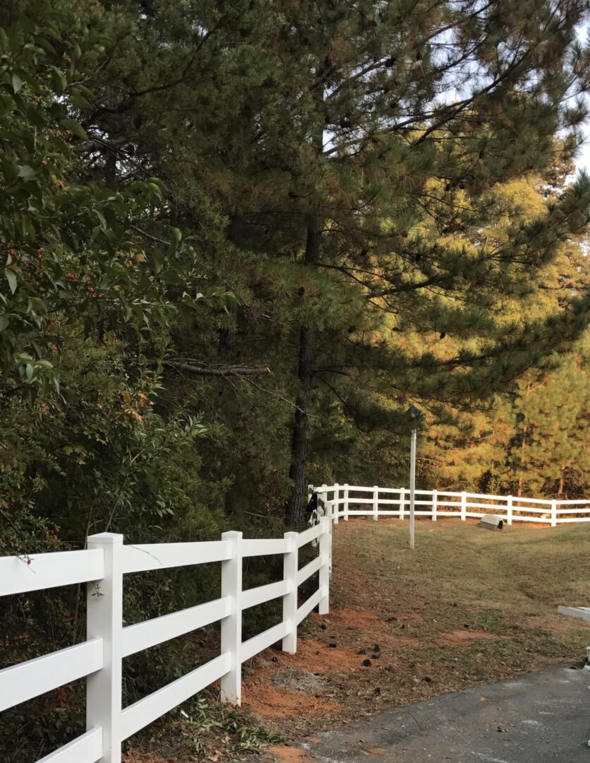 A white fence in the middle of a field.