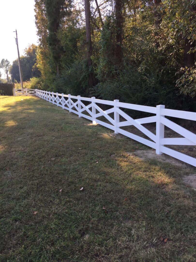 A white fence in the middle of a field.