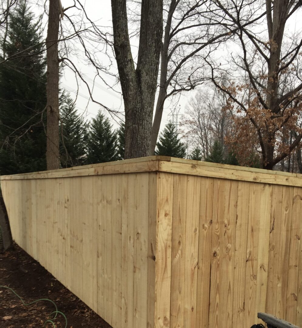 A wooden fence with trees in the background