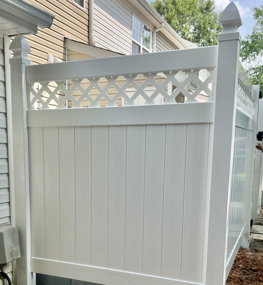 A white fence with a wooden lattice on top.