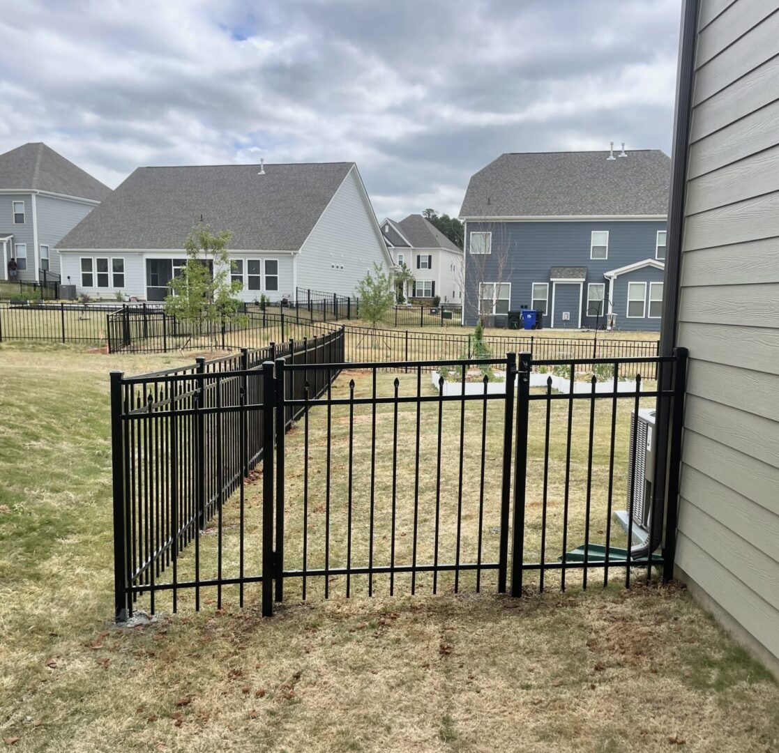 A fenced yard with a house in the background.