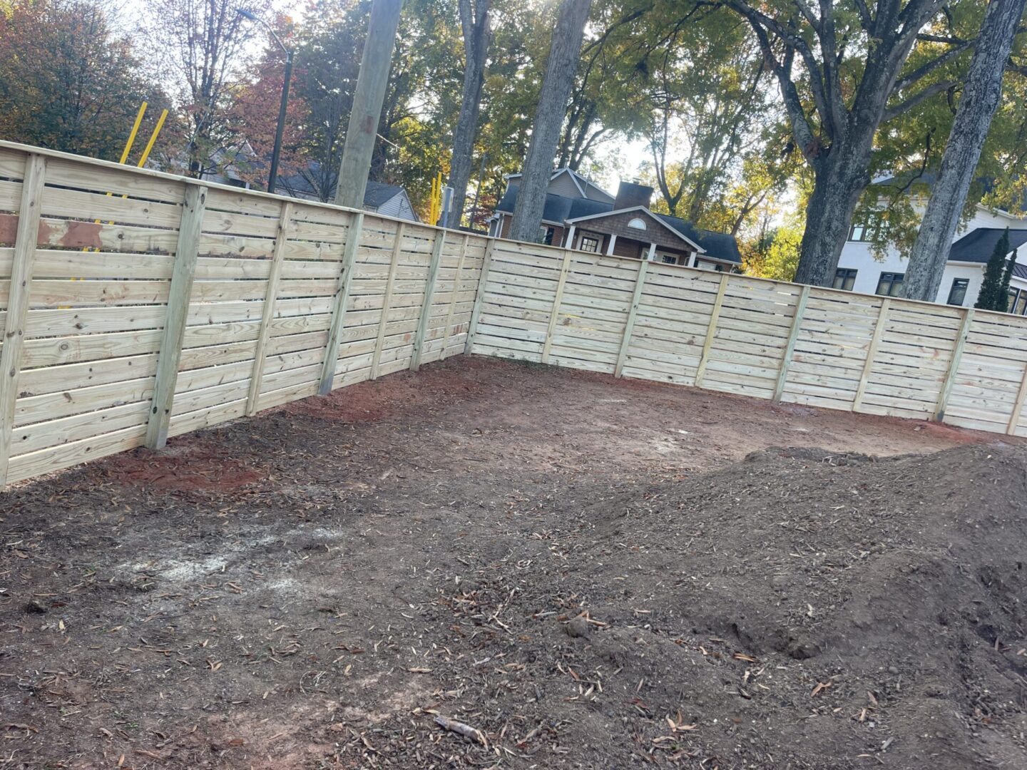 A wooden fence is being built in the dirt.