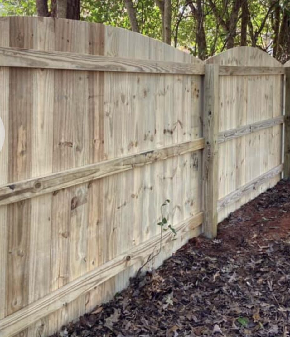 A wooden fence with no leaves on the ground.